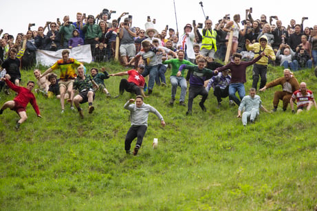 Contestants from 2019 tumble down Cooper's Hill. 