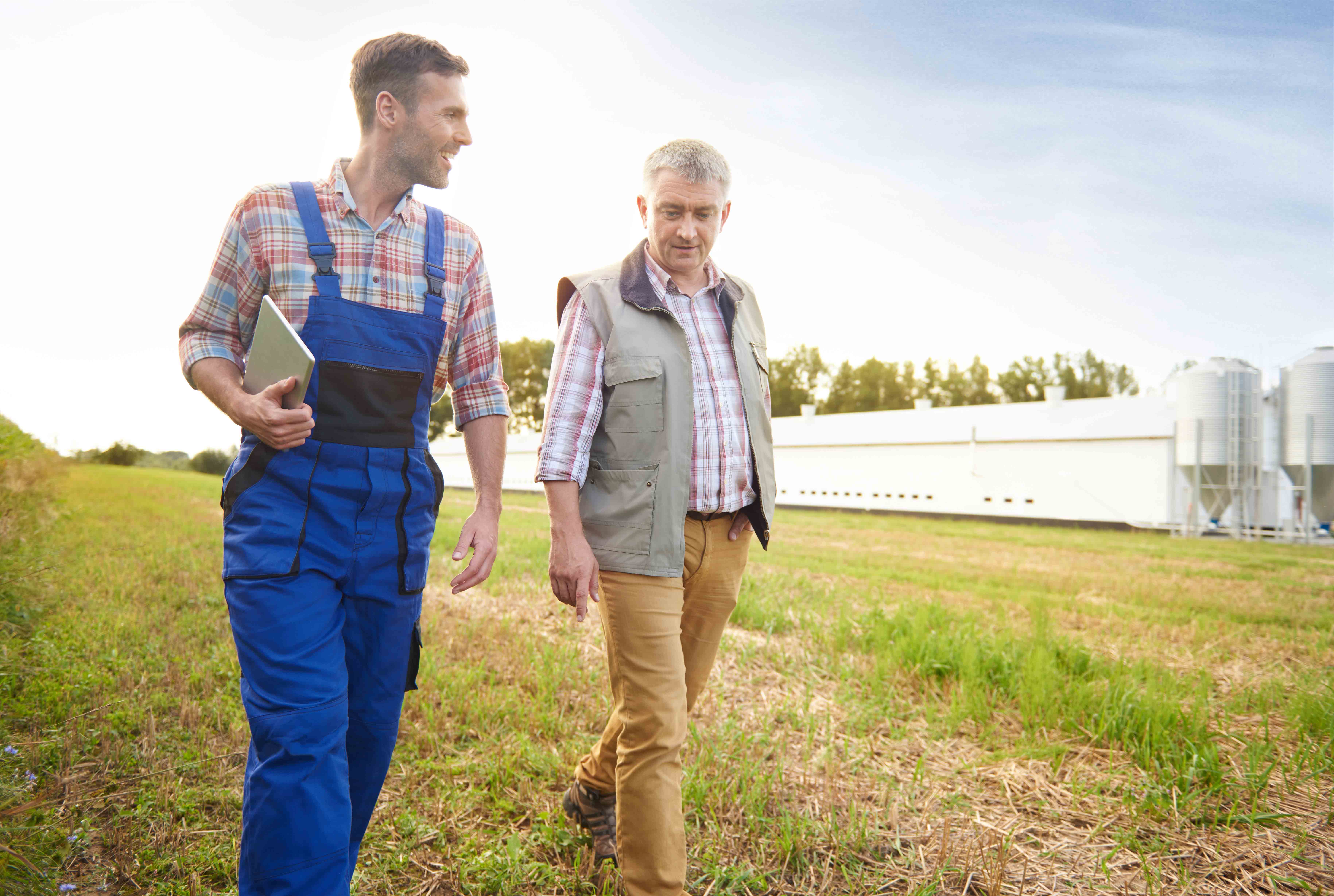 Two farmers walking with iPads